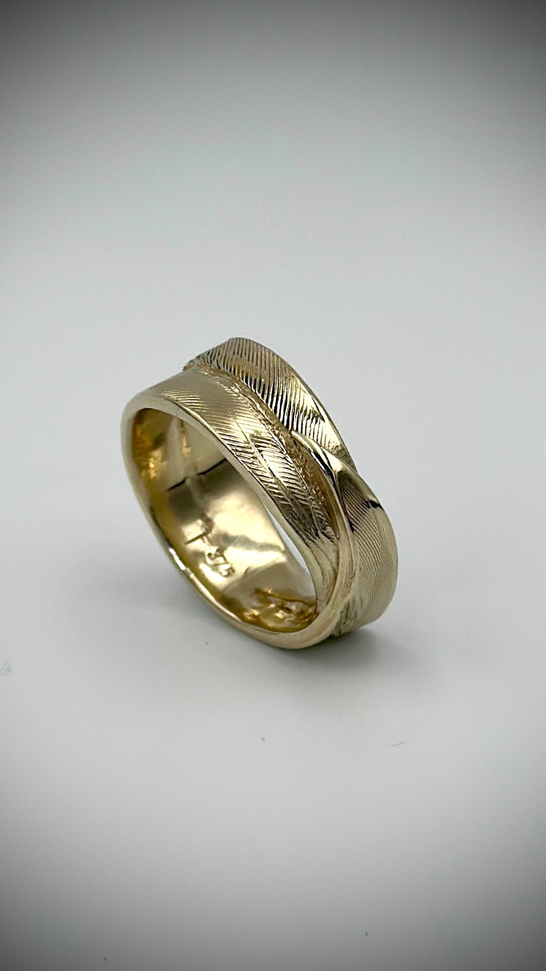 9 carat yellow gold feather ring, angled view showing intricate lost wax cast feather detail across the band with 375 hallmark inside — Marina Fox Fine Art