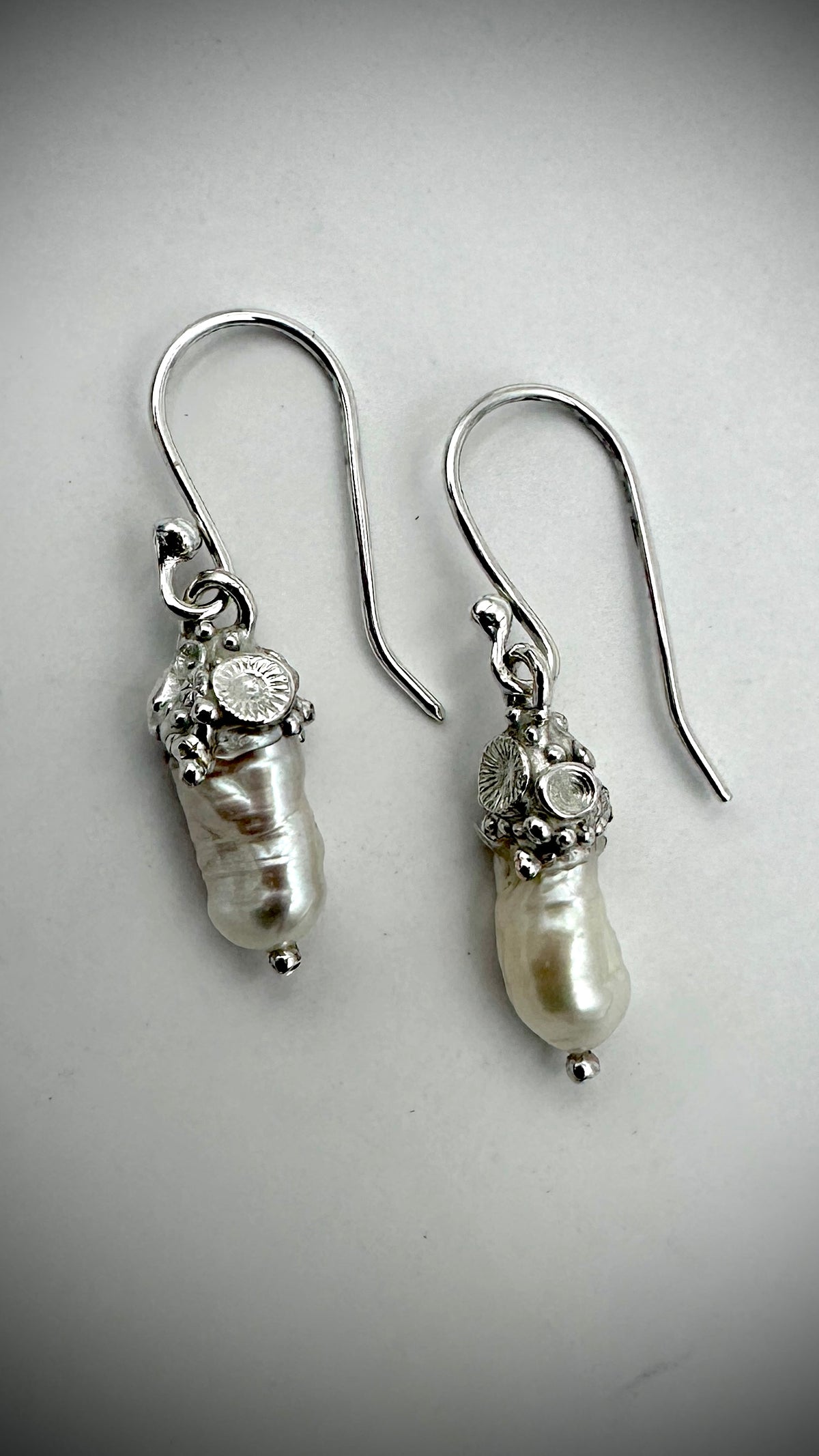 Baroque freshwater pearl drop earrings with one-of-a-kind sterling silver coral cluster caps and handmade sterling silver hooks, shown on white background