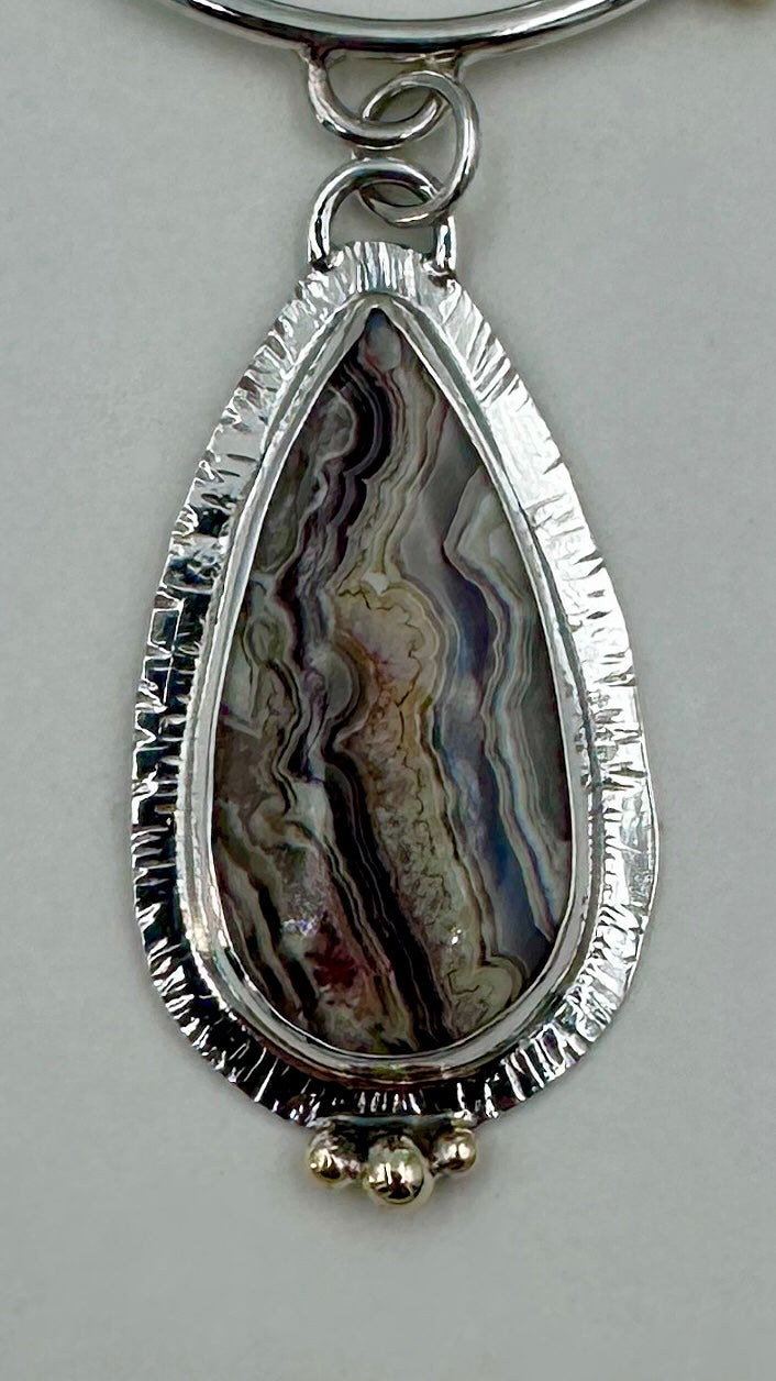 Close-up of Crazy Agate on Barn Owl Sterling Silver pendant showing depth and layered composition	