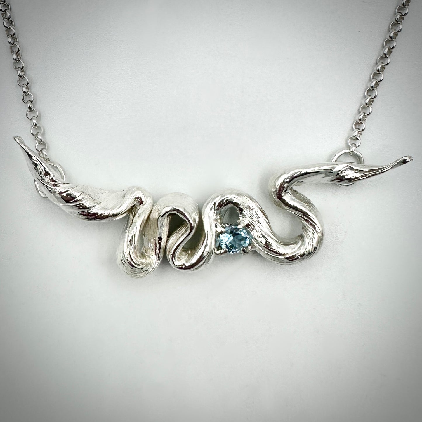 Close-up of hand-made Mitsuro Hikime silver pendant with pale blue Topaz gemstone accent