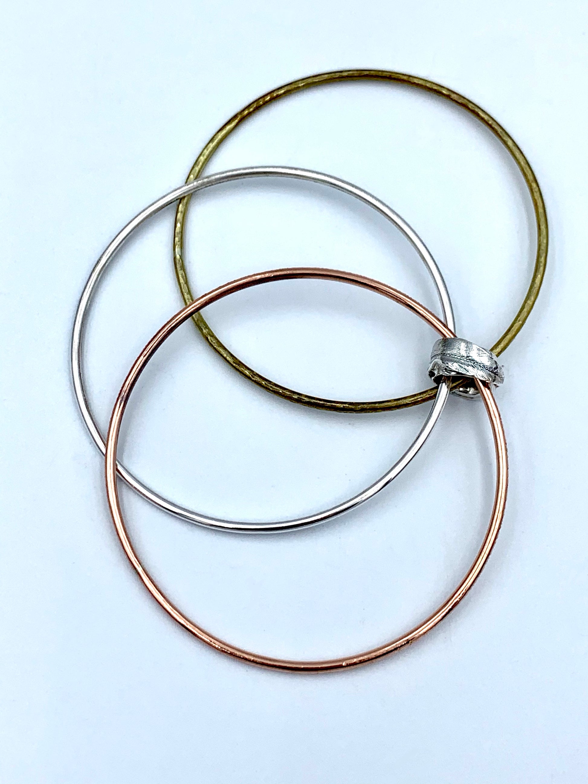 Feather Bead Bangle flat lay showing all three linked bangles - sterling silver, brass and copper, Marina Fox Fine Art