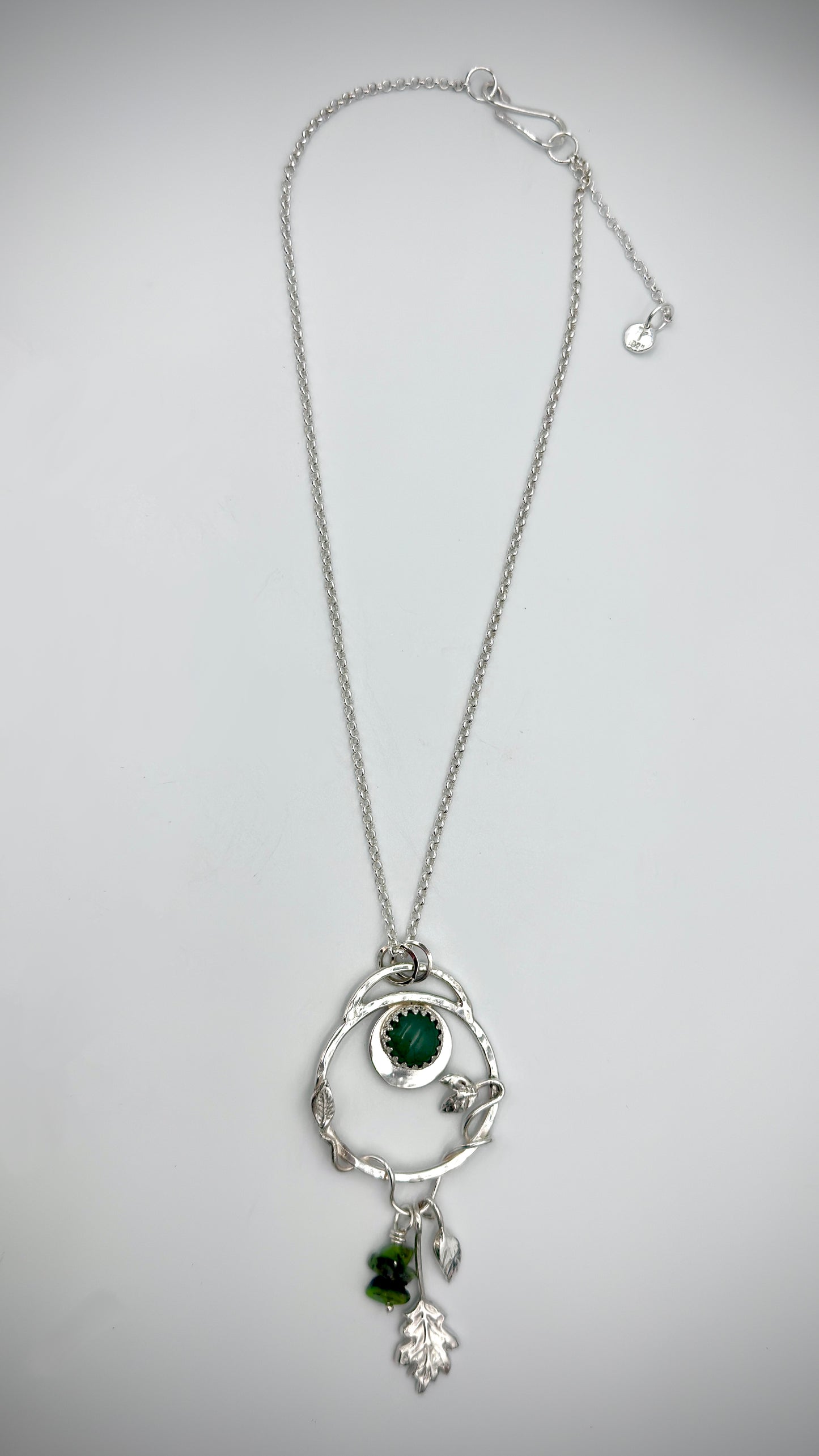 Full-length view of sterling silver Dryad pendant necklace with green aventurine cabochon and botanical leaf charms on belcher chain