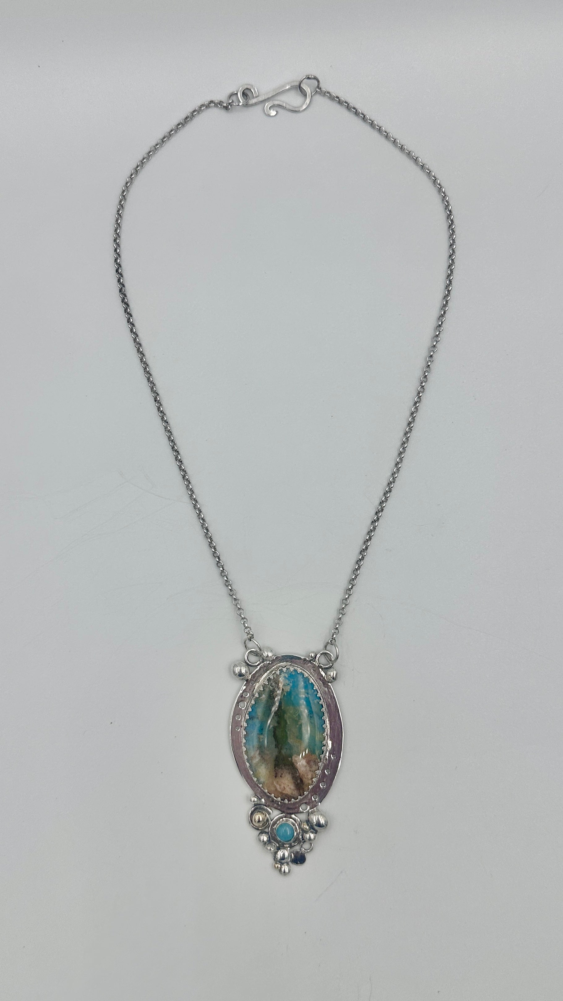 Necklace with a decorative rockpool pendant on a light gray background
