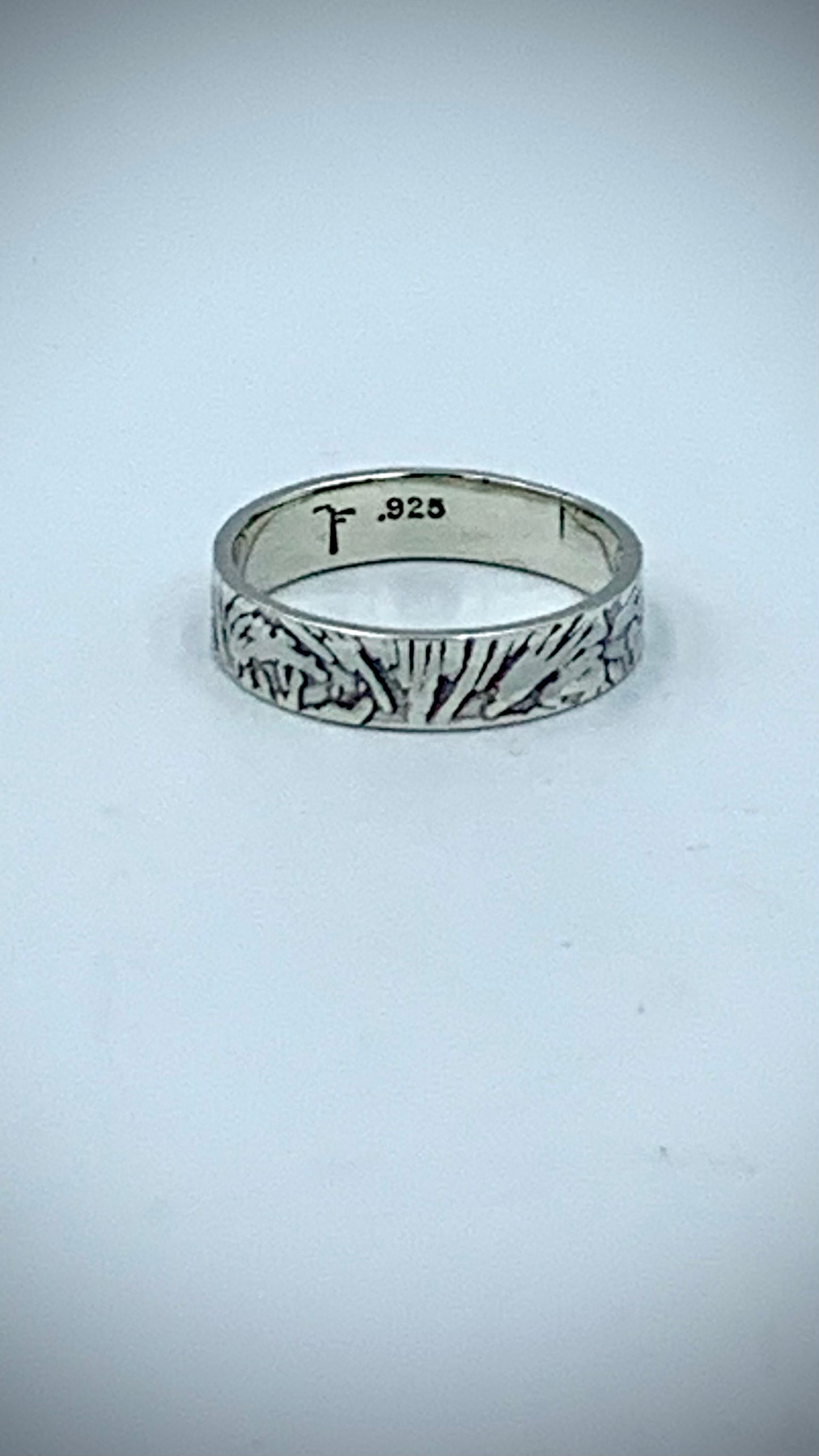 Interior of sterling silver ring showing artist hallmark and .925 stamp, with textured Ginkgo Leaf band
