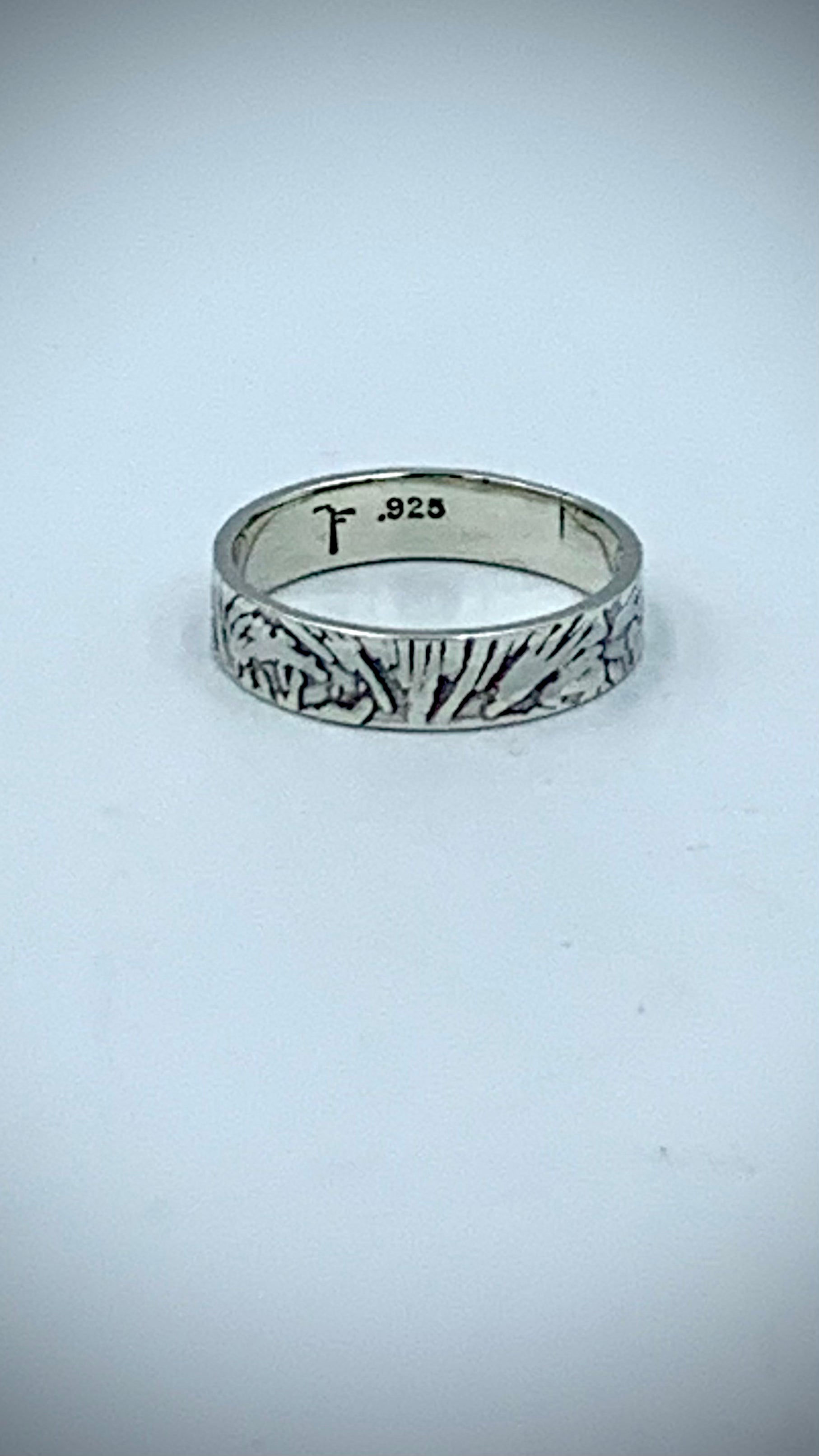 Interior of sterling silver ring showing artist hallmark and .925 stamp, with textured Ginkgo Leaf band