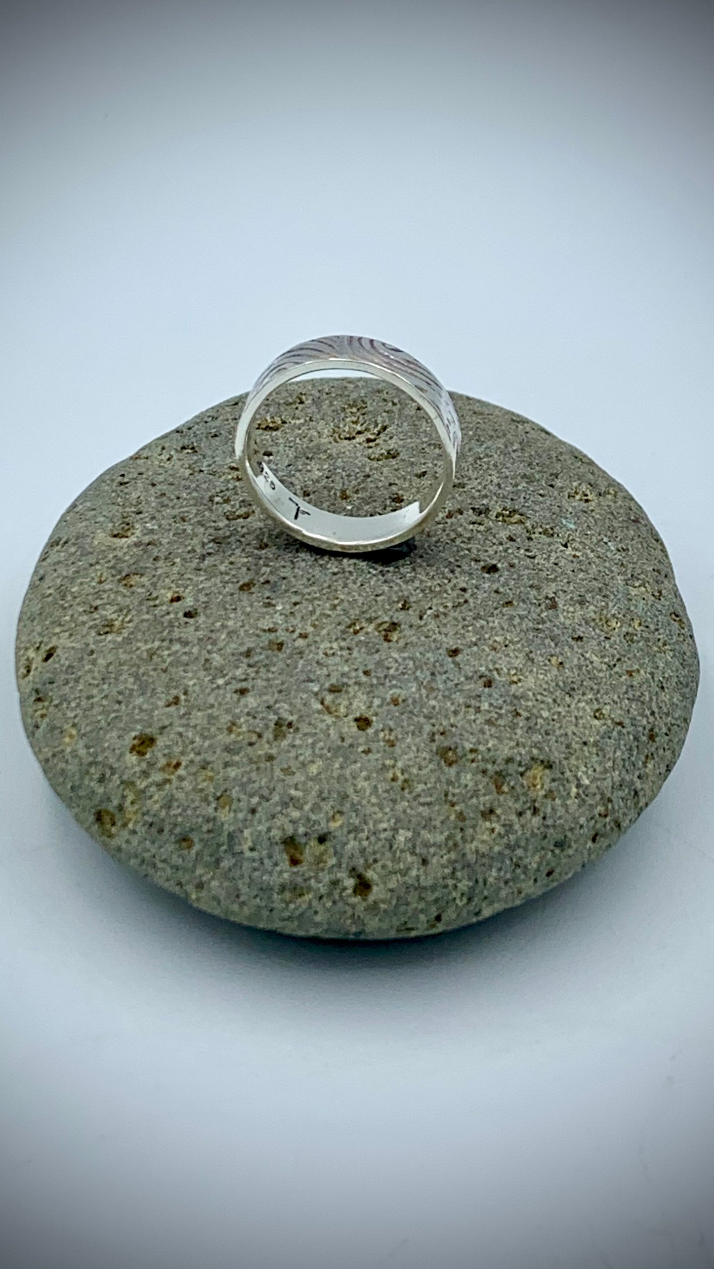 Interior of sterling silver ring showing artist hallmark and .925 stamp, with textured Wave pattern band