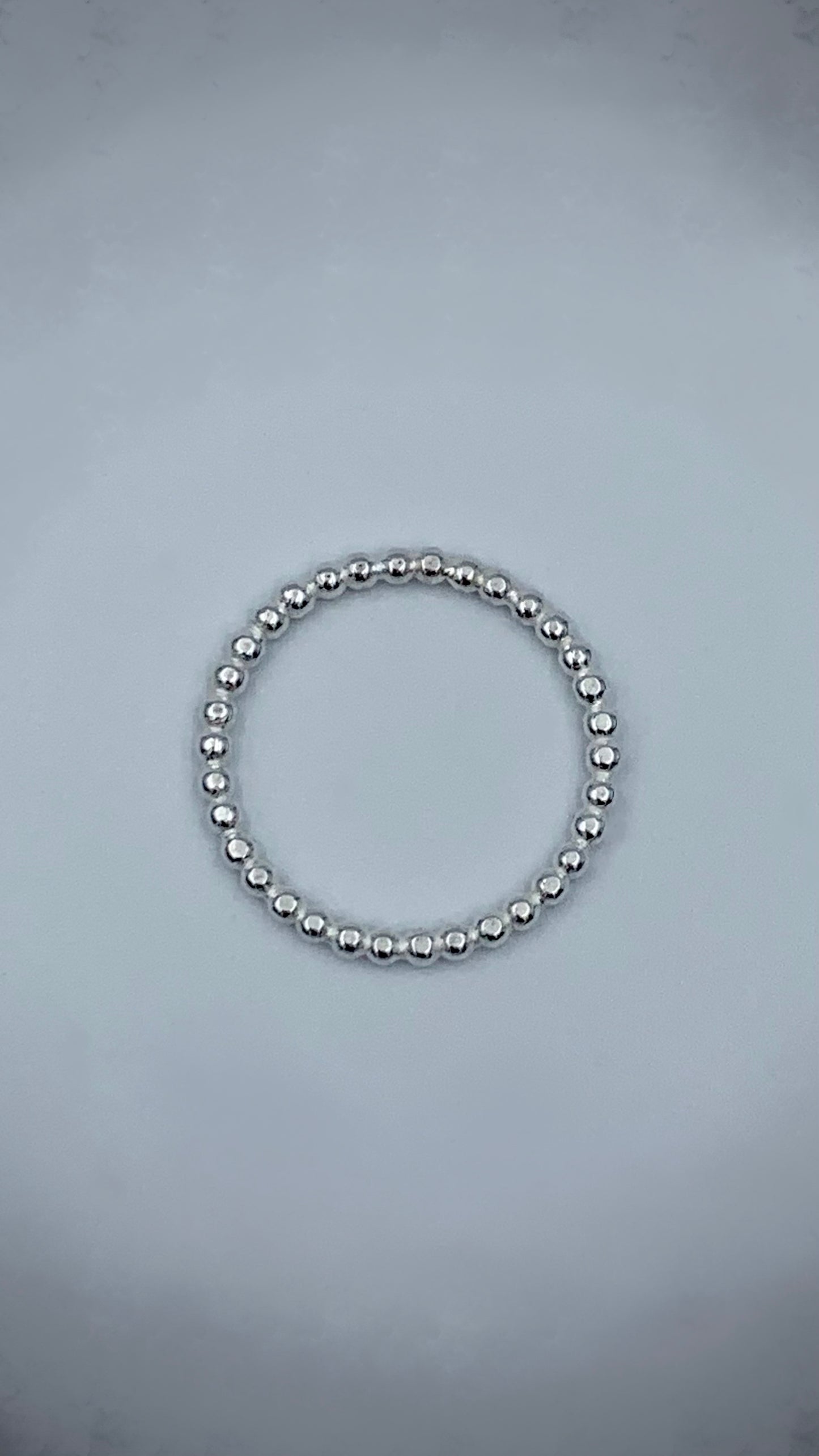 Sterling silver pearl bead stacking ring flat lay, top-down view