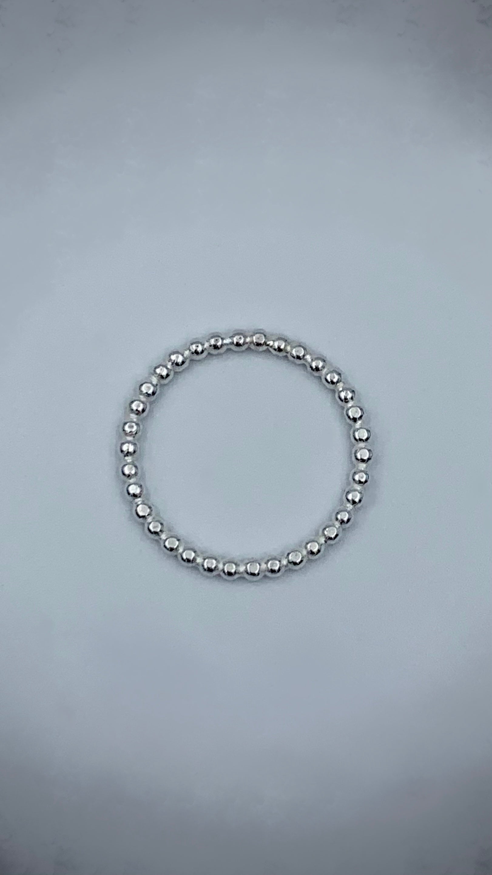 Sterling silver pearl bead stacking ring flat lay, top-down view