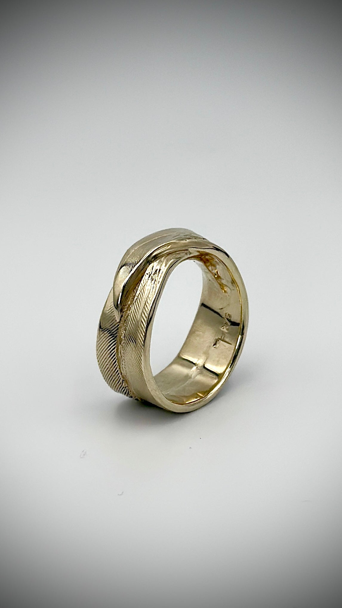 Three-quarter view of 9 carat yellow gold feather ring displaying overlapping band and fine feather texture, handcrafted by Marina Fox Fine Art
